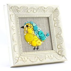 a white frame with a yellow and blue bird in it's center surrounded by buttons