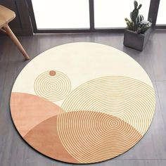 a round rug with an abstract design on the floor next to a potted cactus