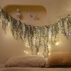 there is a bed with lights on the headboard and pillows in front of it