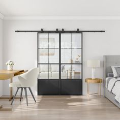 a bedroom with a bed, desk and sliding glass doors