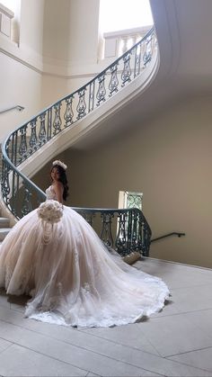 a woman in a wedding dress is sitting on the floor next to a stair case