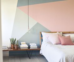 a bedroom with pink, grey and white wall paint on the walls next to a bed