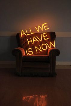 a chair that is sitting on the floor in front of a wall with neon lights