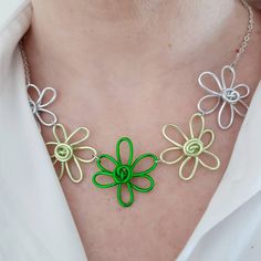 This statement necklace consists of five wire flowers in lovely bright shades of green and silver, hand made in the UK. **Buy with confidence - I have a 14 day no-quibble returns policy on all my items** Update your spring wardrobe with this fun funky floral necklace! You could wear this anywhere, it would be lovely for a summer wedding or party or ress it down and wear it more casually. The quirky aluminium flowers hang from a silver plated chain. Total length is approximately 48cm plus 5cm ext Handmade Green Flower Pendant Necklace, Whimsical Green Flower-shaped Jewelry, Graffiti Flowers, Funky Necklace, Statement Bib Necklace, Unique Gifts For Women, Floral Necklace, Colourful Necklace, Unique Handmade Jewelry