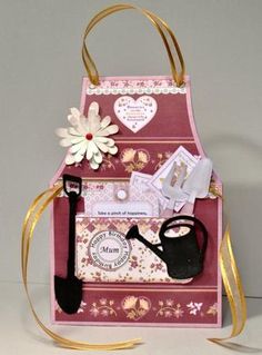 a pink and gold bag with flowers on it is sitting next to a white flower