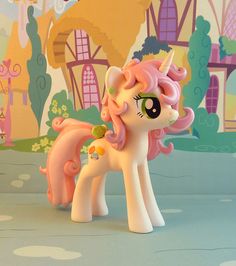 a pink pony toy standing in front of a wall