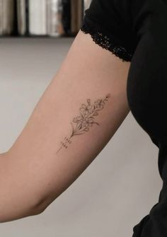 a woman's arm with a tattoo on it that has flowers in the middle