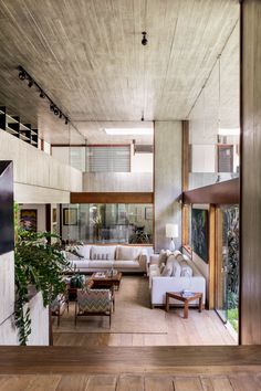 a living room filled with furniture next to a tall wooden floored wall and ceiling