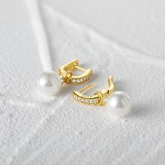 Indulge in the allure of these classic pearl earrings, as they effortlessly elevate any outfit with their refined beauty. These exquisite earrings feature detachable pearl pendants, allowing you to customize your look effortlessly. The hoops are adorned with sparkling white stones, adding a touch of brilliance to your ensemble. Whether worn as a sophisticated statement piece or as a delicate accessory, these earrings are sure to captivate attention and enhance your natural elegance. Embrace the Classic Pearl White Hoop Earrings, Classic Pearl White Pearl Hoop Earrings, Elegant Pearl White Hoop Earrings, Elegant White Pearl Drop Hoop Earrings, Elegant Silver Hoop Earrings With Pearl Pendant, Elegant White Hoop Earrings With Pearl Chain, Classic Elegant Design Pearl Earrings, Classic Elegant Pearl Earrings, Classic White Pearl Earrings For Everyday Elegance