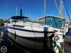 a white boat docked at a dock with other boats