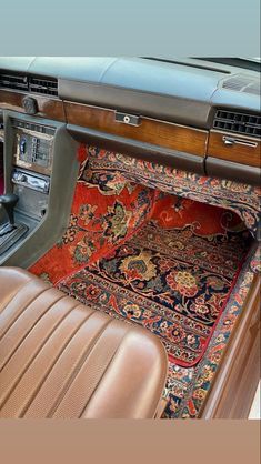 the interior of an old car with carpet and leather seats