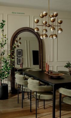 a dining room table with chairs and a mirror