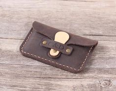 a brown leather wallet sitting on top of a wooden table