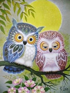 two owls sitting on a branch with flowers