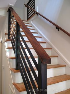 an image of a stair case with wood handrails and metal railing on the bottom