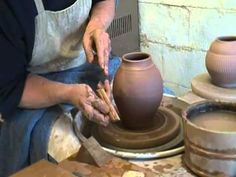 a person is making a vase out of clay