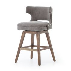 an upholstered bar stool with grey fabric and wooden legs, in front of a white background