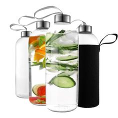 four water bottles filled with different types of fruit and veggies next to each other