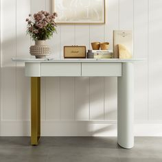 a white table topped with a vase filled with flowers