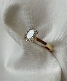 a diamond ring sitting on top of a white cloth