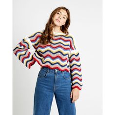 a woman is wearing a colorful sweater and jeans