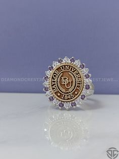 an image of a ring with the university seal on it's center and surrounded by diamonds