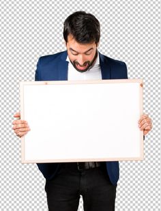 a man in a suit holding up a white board with his mouth wide open and looking down