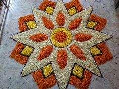 an orange, yellow and white flower is on the floor