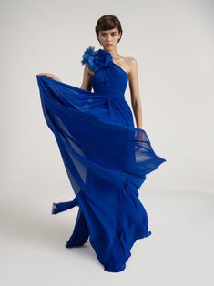 a woman in a blue dress poses for the camera