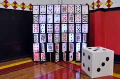 two dices sitting on top of a wooden floor next to a display of playing cards