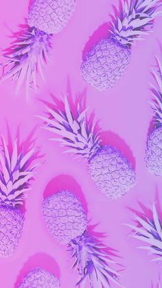 several pineapples are arranged on a pink background