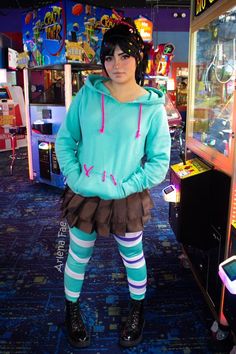 a woman standing in front of a vending machine wearing a hoodie and striped tights