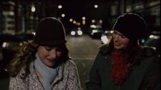 two women walking down the street at night