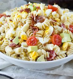 a white bowl filled with pasta salad on top of a table