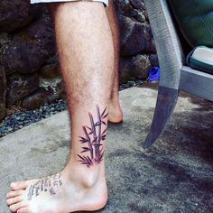 a man with a tattoo on his foot has a bamboo plant tattooed on the leg