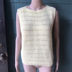 "Amazing vintage 70's pale yellow crochet tank top. Square shape, high neckline. Open at the armpit to the bottom edge. Size medium. Acrylic feel. No tags, handmade. Excellent vintage condition! So perfect. Will best fit small/medium. Measurements laying flat: fabric stretches. Pit to pit/waist: 16-18\" length: 22.5\"" Vintage Fitted Sleeveless Crochet Top, Fitted Vintage Sleeveless Crochet Top, Vintage Yellow Sleeveless Top, Vintage Sleeveless Crochet Top For Spring, Cream Hand Knitted Top, Hand Knitted Cream Knit Tops, Vintage Crochet Sleeveless Vest, Fitted Sleeveless Hand-knitted Top, Hand Knitted Fitted Sleeveless Top