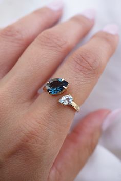 a woman's hand with a blue and white diamond ring