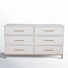 a white dresser with gold handles and drawers