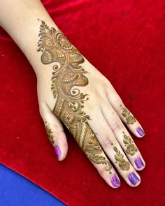 a woman's hand with hennap on it and purple nail polishes