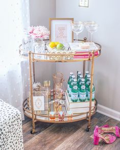 a gold bar cart with drinks on it