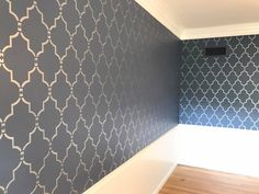 an empty room with blue and white wallpaper