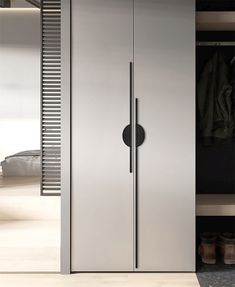 a tall stainless steel refrigerator freezer next to a closet with shoes on the floor