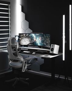 a computer desk with two monitors and speakers on it in front of a black wall