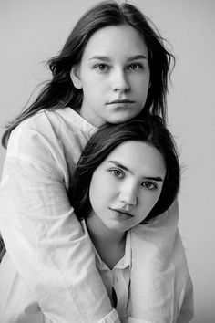 two women are posing for the camera in black and white, with one woman leaning on her shoulder