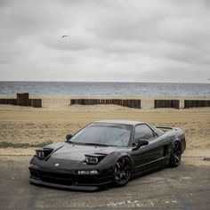 a black sports car parked on the beach