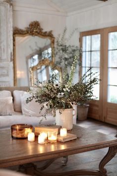 candles and flowers on a coffee table in a living room