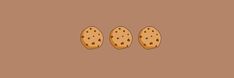 three cookies sitting in the middle of a brown background with one cookie on it's side