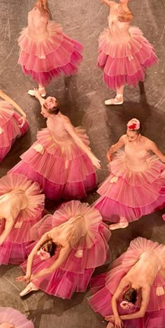 dancers in pink tutu skirts are performing on the floor with their arms spread out