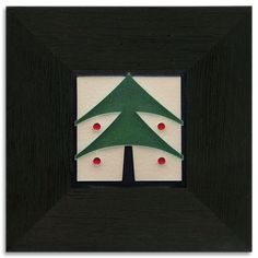 a green christmas tree in a black frame with red berries on the bottom of it