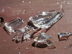 broken glass pieces sitting on top of a wooden table